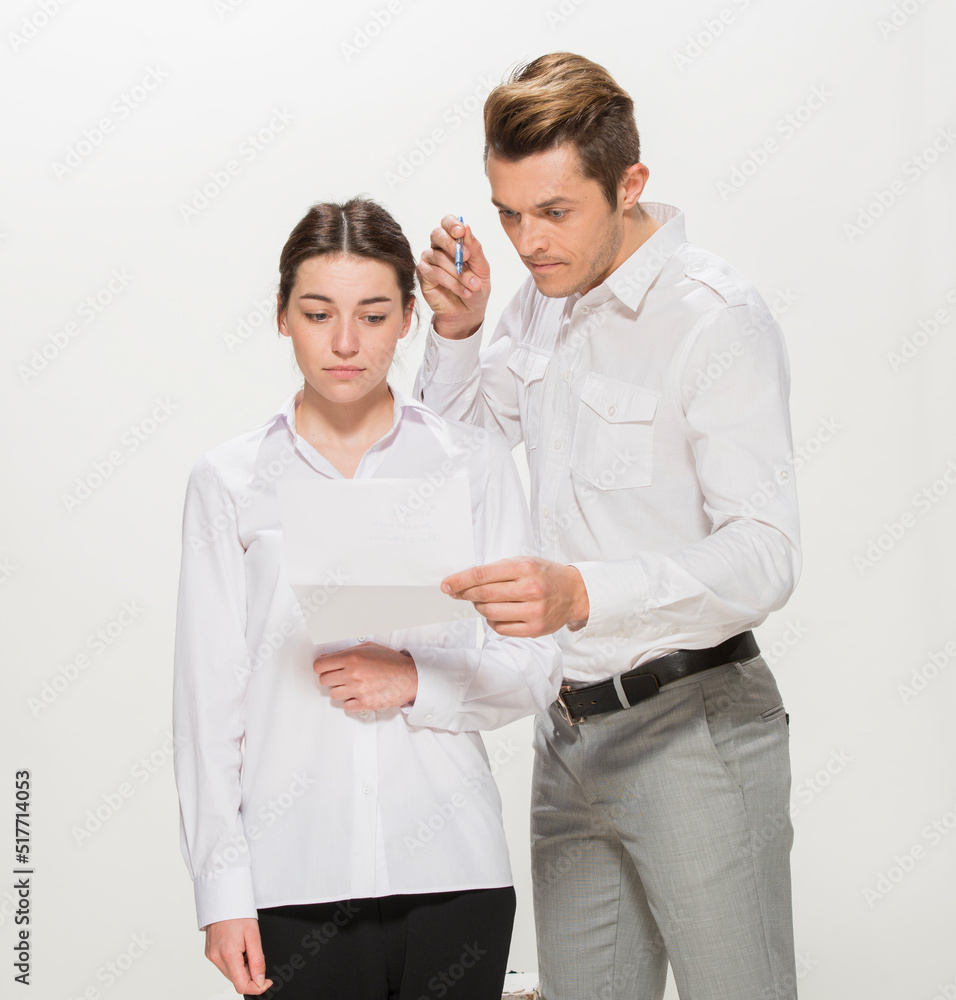 the boss scolds the young subordinate.close-up portrait of two workers on a white background isolated.the man yells at the girl.teaches the girl.points out the mistakes. the boss scolds the young subordinate.close-up portrait of two workers on a white background isolated.the man yells at the girl.teaches the girl.points out the mistakes.