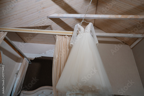 wedding dress hanging on hangers © Oksana