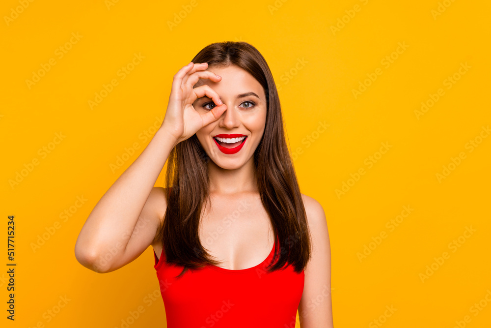 Portrait of pretty positive lady hand fingers make binocular watch look camera isolated on yellow color background Portrait of pretty positive lady hand fingers make binocular watch look camera isolated on yellow color background