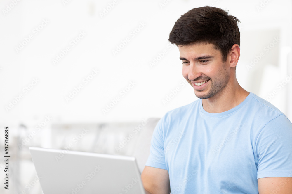 Young smiling man with laptop close-up at home