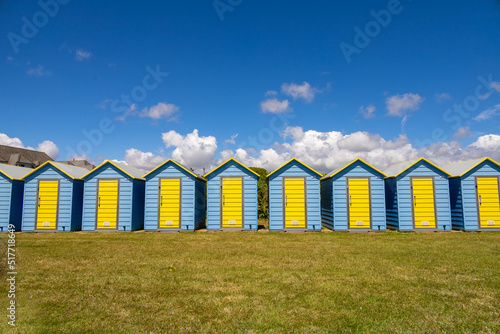 Shades of blue. A day in the british south coast, in Felpham, near brighton. Beautiful brighty colored blue and yellow beach huts in the lawn bhind the beach. British summer atmosphere. photo