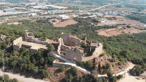 stunning orbiting aerial of Castell de Palafolls located in Palafolls, Barcelona, Cataluña, Spain.  The castle ruins are a major tourist attraction and have a long history. since medieval times. photo