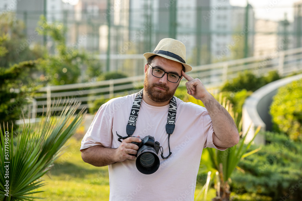 photographer on the photoshoot in hat at park with camera professional guy photographer on the photoshoot in hat at park with camera professional guy