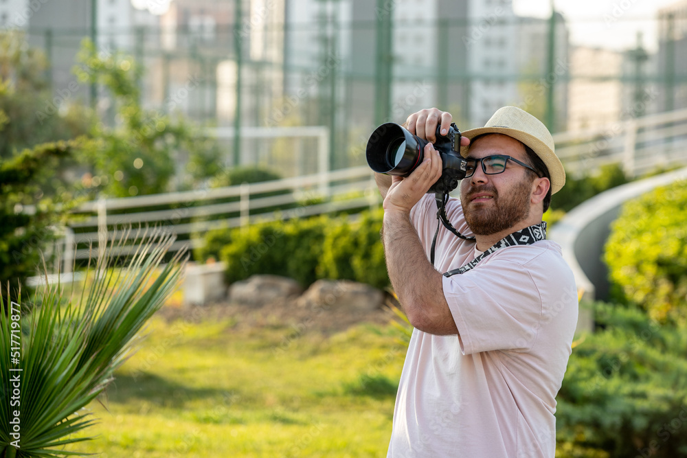 photographer on the photoshoot in hat at park with camera professional guy love his job photographer on the photoshoot in hat at park with camera professional guy love his job