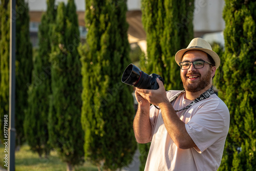 Photography photographer on the photoshoot in hat at park with camera professional guy happy