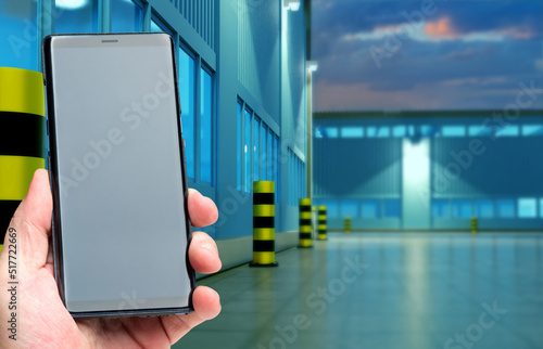 Phone in man hand. Warehous...