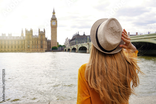 Tourism in London. Back view of tourist woman enjoying sight of Westminster palace and bridge on Thames with famous Big Ben tower in London, UK.