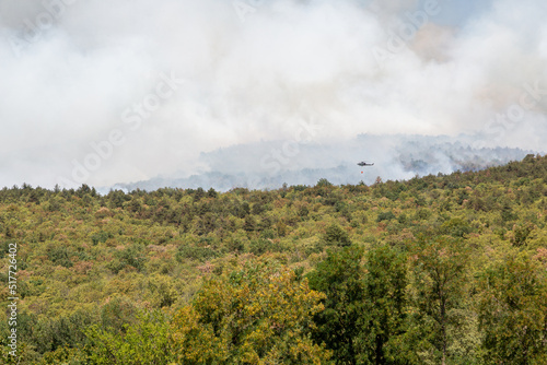 Helicopter against wildfire during strong wind and drought