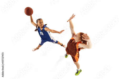 Aerial view of female basketball players, young girls, teen playing basketball isolated on white background. Concept of sport, team, enegry, competition, skills © master1305