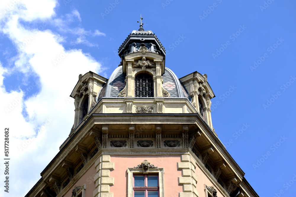 Classic old decorative roof dormer detail in Budapest. blue sky. white clouds. closeup building detail. architecture, travel, tourism  concept. summer season. zink dome and roof cover. stucco facade.