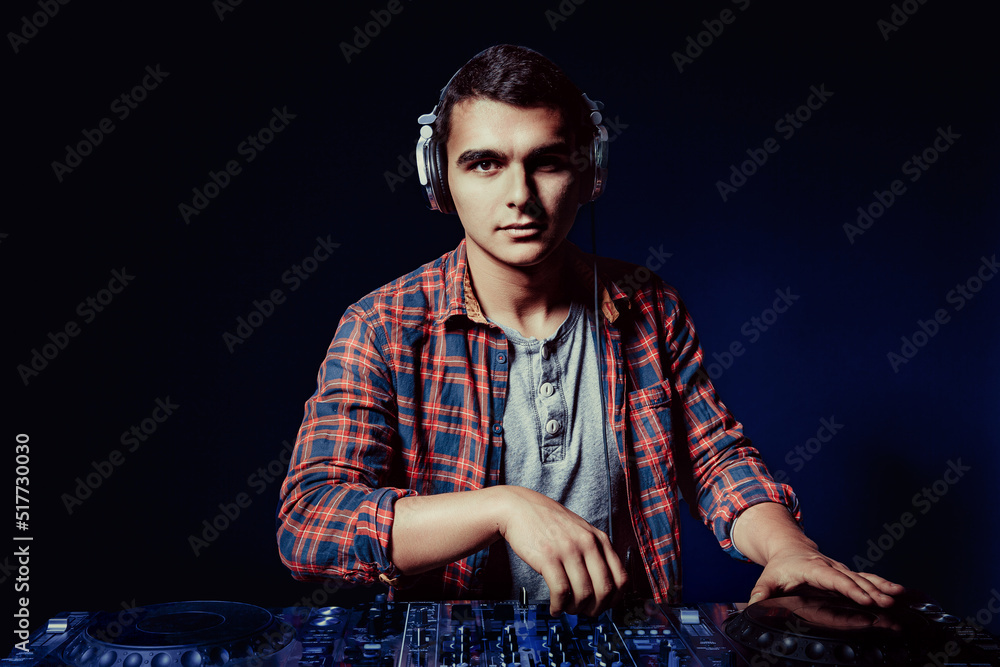 exicted dj sound device oprator with headphones by dancing at club - concept of entertainment, nightlife, music club and musician exicted dj sound device oprator with headphones by dancing at club - concept of entertainment, nightlife, music club and musician
