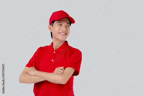 Young asian man in uniform red and cap standing arms crossed with confident isolated on white background, employee or dealer, courier and delivery, deliveryman and expression, logistic and cargo.