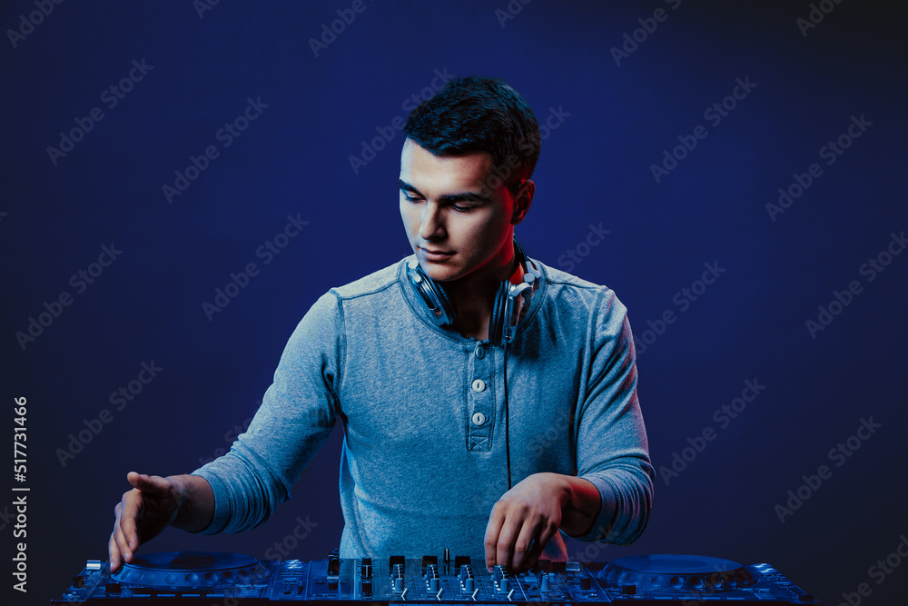 exicted dj sound device oprator with headphones by dancing at club - concept of entertainment, nightlife, music club and musician exicted dj sound device oprator with headphones by dancing at club - concept of entertainment, nightlife, music club and musician