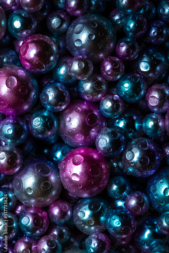 Beautiful background with nacreous dark pearls, top view. Abstract texture for festive backgrounds. Shiny multicolored dark surface of Christmas decorations. Gems close-up. Black bright background.