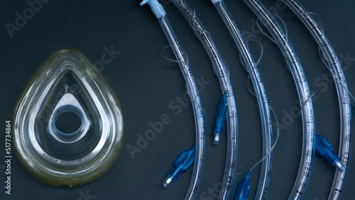Endotracheal tubes of different diameters and a mask for a ventilator lie on a dark background. close-up. medical instruments, anesthesia instruments