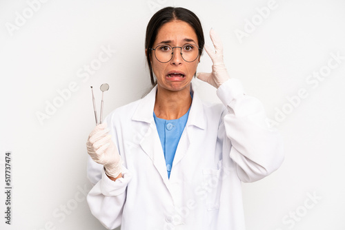 hispanic pretty woman screaming with hands up in the air. dentist student concept