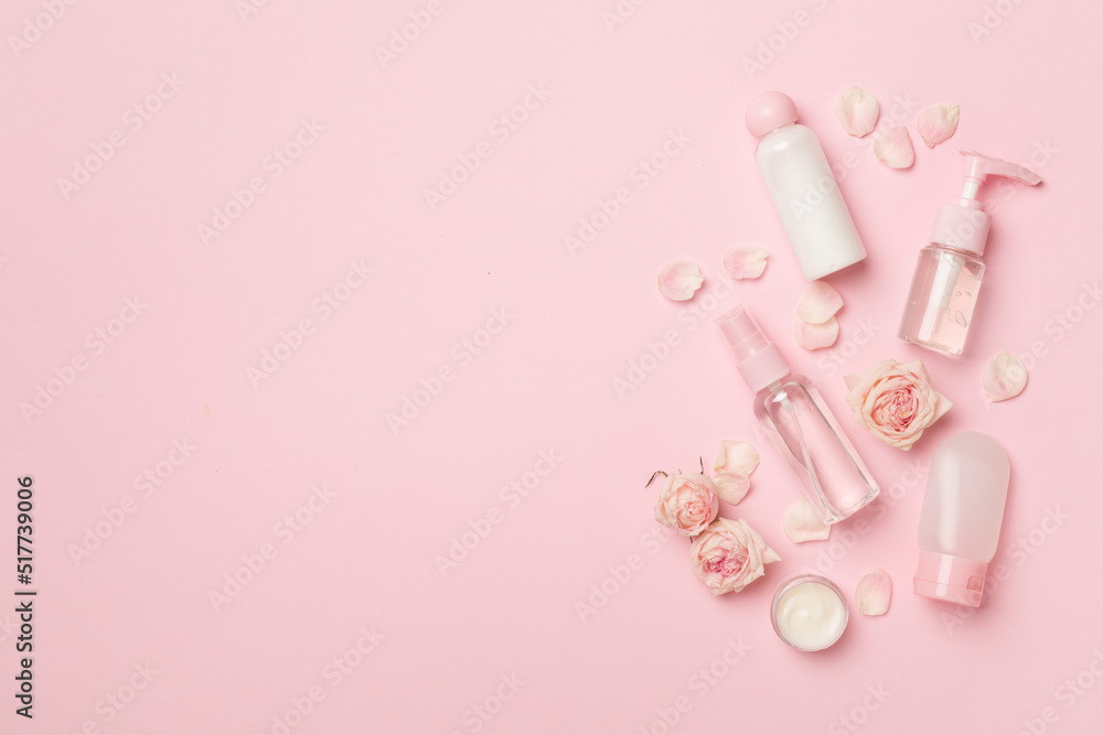 Set of small cosmetic bottles on color background, top view