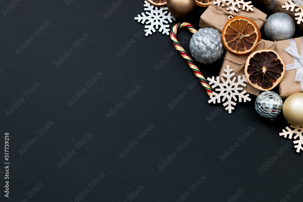 Naklejka premium Beautiful Christmas golden silver decorations on a dark black background. Flat design, postcard, calendar, banner. Place for text.