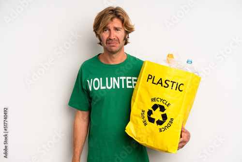 blond adult man feeling sad and whiney with an unhappy look and crying. ecology concept photo