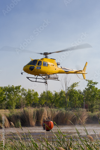 Emergency helicopter recharging water to extinguish a forest fire photo