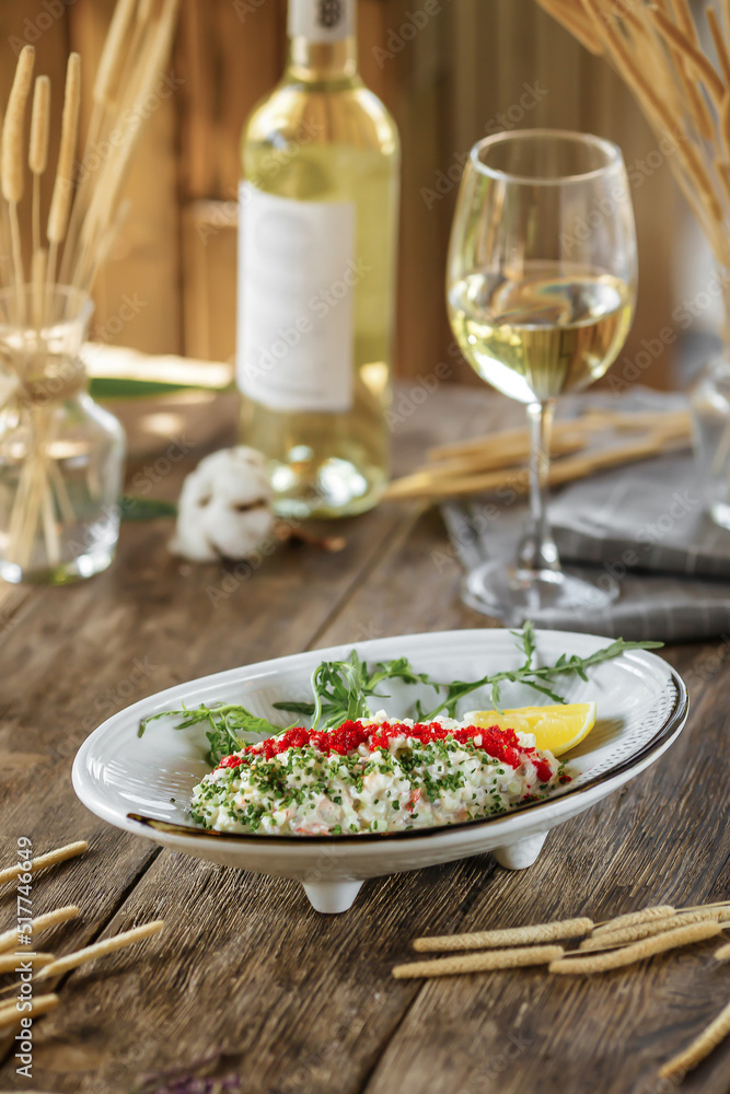 Closeup on gourmet salad with caviar and crab sticks with white wine Closeup on gourmet salad with caviar and crab sticks with white wine