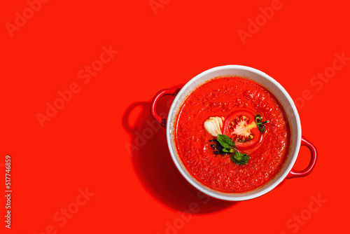 Spicy tomato soup. Healthy vegan hot dish, croutons, vintage cutlery. Bright red background