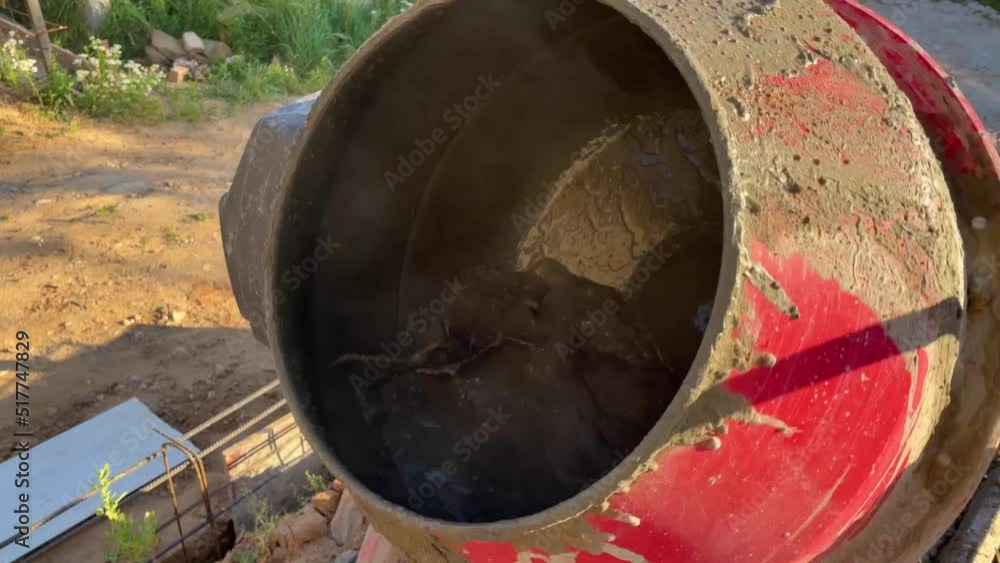 house construction, red concrete mixer works. kneading cement mortar from sand and gravel. moments of construction work house construction, red concrete mixer works. kneading cement mortar from sand and gravel. moments of construction work