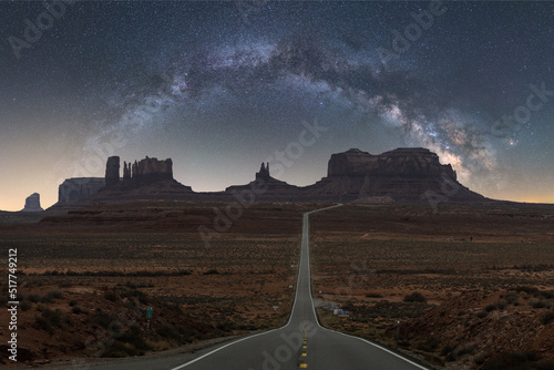 Scenic mountain in between asphalt highway under milky way starry sky