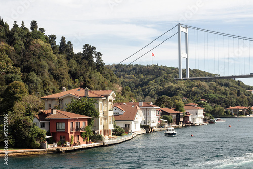 View of historical, traditional mansions by Bosphorus in Kanlica area of Asian side of Istanbul. Boats and FSM bridge are also in the view. It is a sunny summer day. Beautiful travel scene. photo