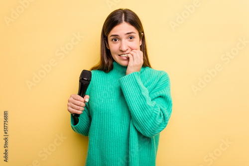 Konstfotografi Young caucasian singer woman isolated on yellow background biting fingernails, nervous and very anxious