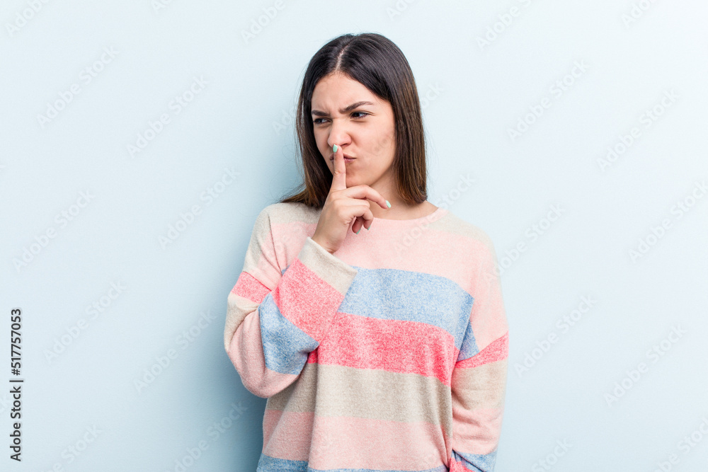 Young caucasian woman isolated on blue background keeping a secret or asking for silence. Young caucasian woman isolated on blue background keeping a secret or asking for silence.