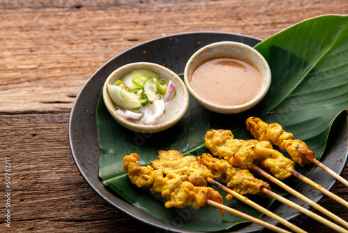 Thai Pork Satay, Moo Satay Grilled pork served with peanut sauce or sweet and sour sauce - Asian food Concept style on wooden table background. 