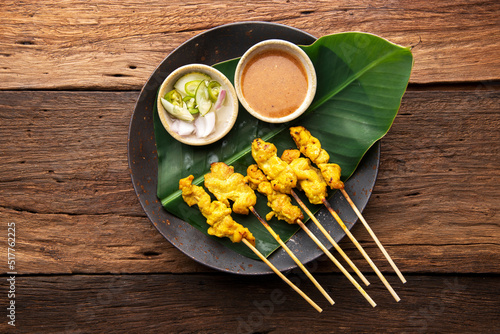 Thai Pork Satay, Moo Satay Grilled pork served with peanut sauce or sweet and sour sauce - Asian food Concept style on wooden table background. Top view