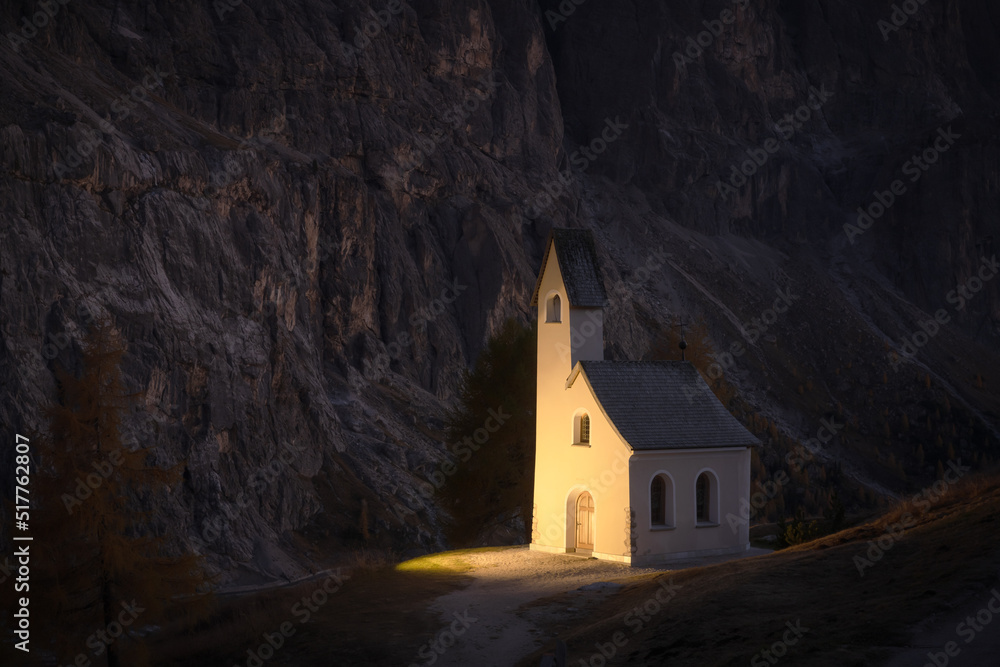 Incredible view on small iIlluminated chapel - Kapelle Ciapela on Gardena Pass, Italian Dolomites mountains. Dolomite Alps, Italy. Landscape photography - obrazy, fototapety, plakaty 