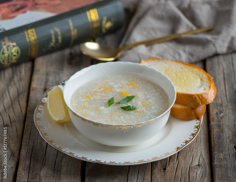 chicken corn soup with garlic bread served in a bowl isolated on wooden background side view of soup chicken corn soup with garlic bread served in a bowl isolated on wooden background side view of soup