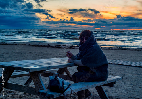 Happy senior of woman sitting on a bench during sunset in Jurmala - famous to...