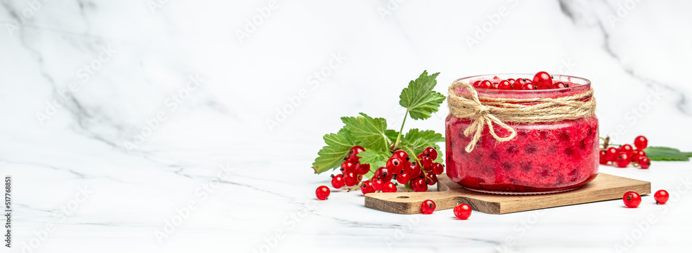 Naklejka premium red currant jam in jar. Canned fresh berries on a light background. Long banner format