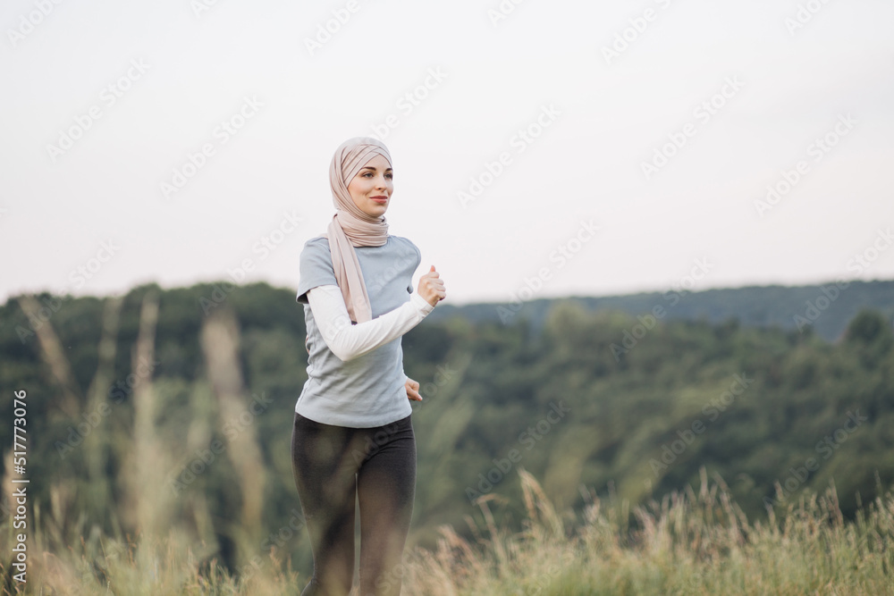 Healthy sport woman in hijab in active clothes enjoying morning run at green park. Muslim woman in hijab spending leisure time for training on fresh air. Healthy sport woman in hijab in active clothes enjoying morning run at green park. Muslim woman in hijab spending leisure time for training on fresh air.