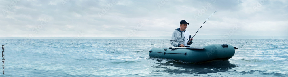 Man fishing with rod from inflatable rubber boat on river, space for text. Banner design
