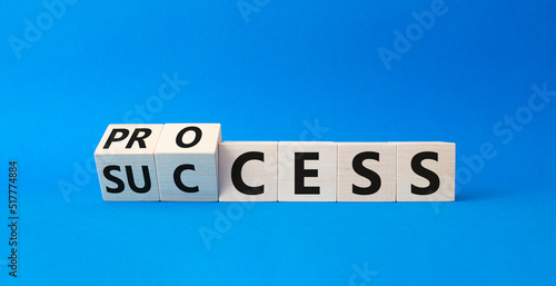 Process and Success symbol. Turned cubes with words success and process. Beautiful blue background. Business and process and success concept. Copy space