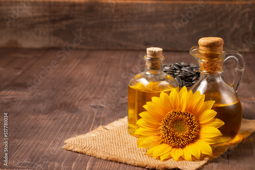 Closeup photo of sunflower oil with seeds on wooden background. Bio and organic product concept. #517780034