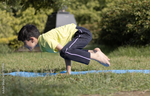 Young boy Practicing Yoga Outdoors in the park in Morning, healthy lifestyle concept, Kids yoga