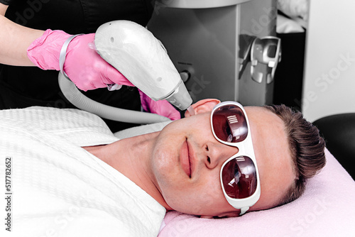 Quadro em tela A close-up of a handsome young man with glasses in front of his eyes undergoing a laser hair removal procedure in a beauty salon