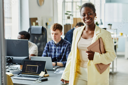 Obraz na płótnie Portrait of African young IT specialist with folder smiling at camera standing a