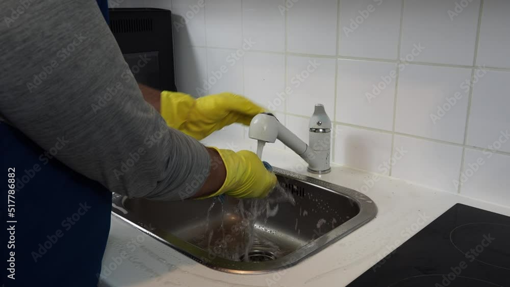 Cropped view of a man cleaning the kitchen. Cropped view of a man cleaning the kitchen.