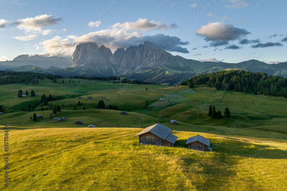 Aerial view of Seiser Alm valley with traditional wooden mountain huts in Dolomites Italy . Morning drone shot of idyllic Alpe di Suisi blooming meadow in South Tyrol