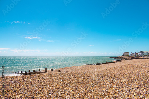 Shades of blue. A day in the british south coast, in Felpham, near brighton. View of the beach of pebbles or rocks ,bright blue sea and sky, sunny day. Beautiful summer day in Britain.