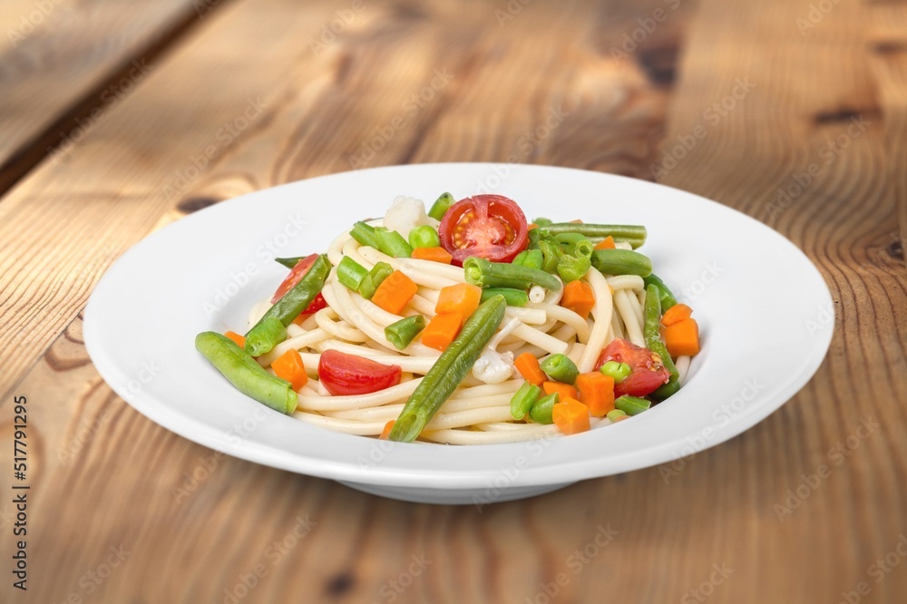 Classic Italian Pasta Spaghetti on plate with wooden table background. Simple and easy vegetarian dish.