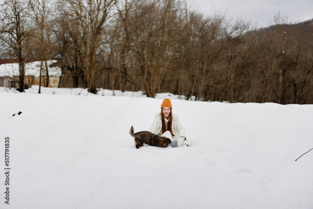 cheerful woman in the snow playing with a dog fun friendship winter holidays cheerful woman in the snow playing with a dog fun friendship winter holidays