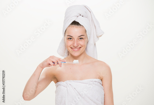 beauty portrait of a cheerful girl with a towel on her head isolated.Facial skin care and health concept.close-up on a white background. girl holding a glass holding an apple brushing her teeth making